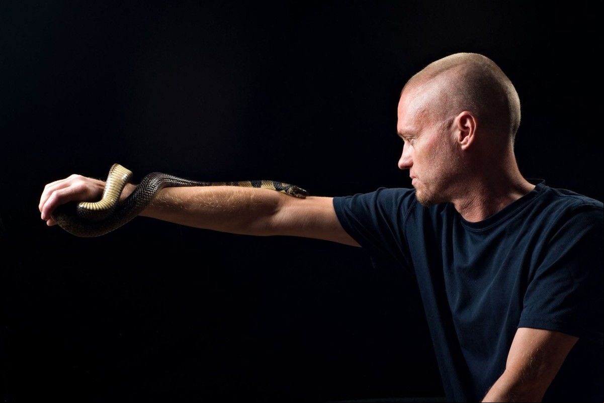 This undated handout photograph obtained from Centivax on May 30, 2025, shows US' Tim Friede, 57, who has exposed himself to snake venom hundreds of times with an aim to build up immunity, posing with a water cobra. From 2000 to 2018, Friede allowed himself to be bitten by snakes more than 200 times and also injected himself with their venom over 650 times, in an attempt to achieve total immunity to venom, a practice called mithridatism. In May 2025, a study published in the prestigious Cell journal showed that antibodies from his blood protect against a range of snake venom. The researchers now hope Friede's hyper-immunity could even lead to the development of a universal antivenom. (Photo by CENTIVAX / AFP) / RESTRICTED TO EDITORIAL USE - MANDATORY CREDIT "AFP PHOTO /  CENTIVAX" - HANDOUT - NO MARKETING NO ADVERTISING CAMPAIGNS - DISTRIBUTED AS A SERVICE TO CLIENTS
